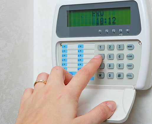 Hand Using Alarm System for Alarm Monitoring Services in Los Angeles, CA